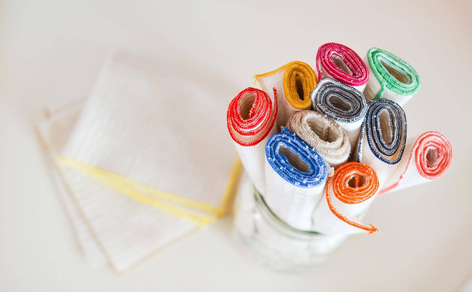 reusable paper towels bordered with vibrant colors folded in a jar
