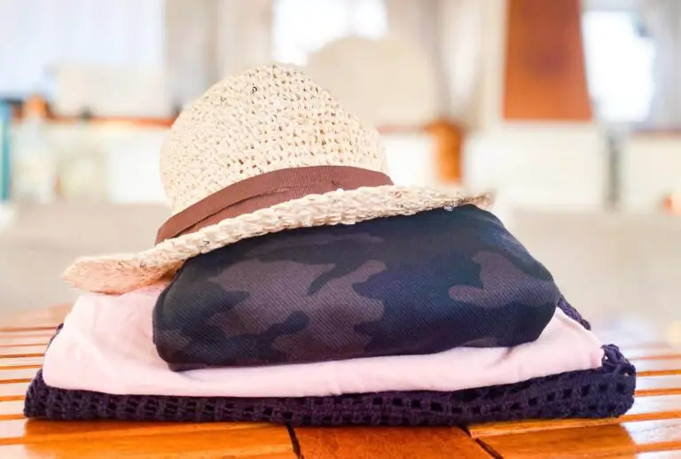 Fedora straw hat on top of folded camo leggings and tops.
