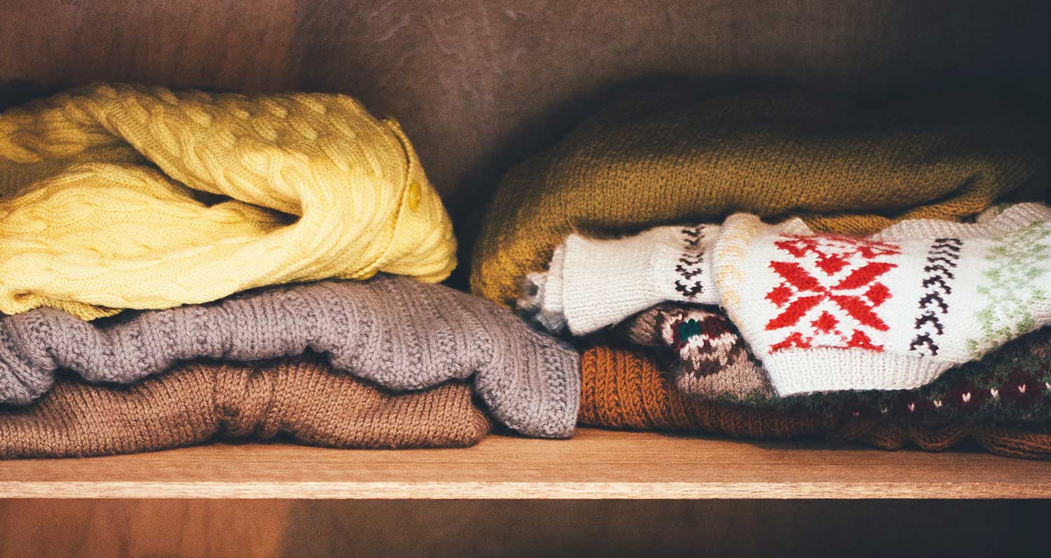 sweaters disorganized on shelf