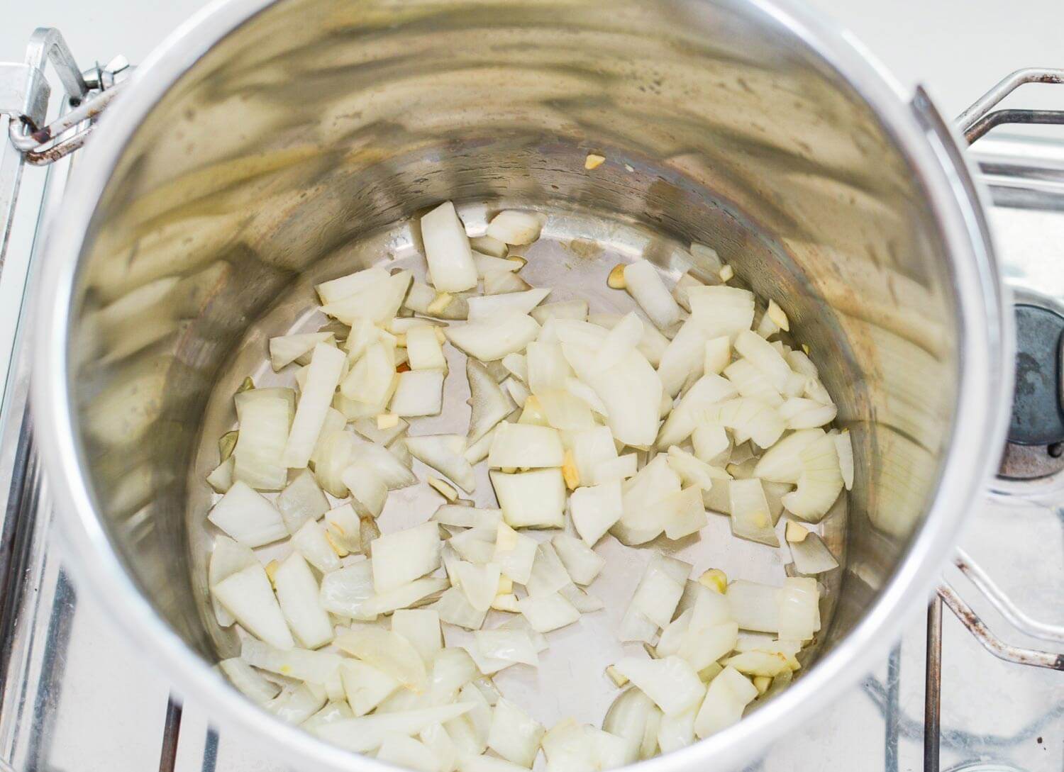 thermal cooker on stove sautéing onion 