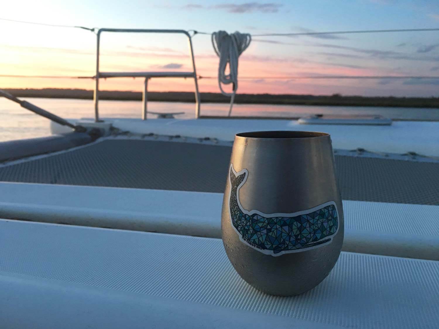 stainless steel wine glass on boat deck with sunset in the background