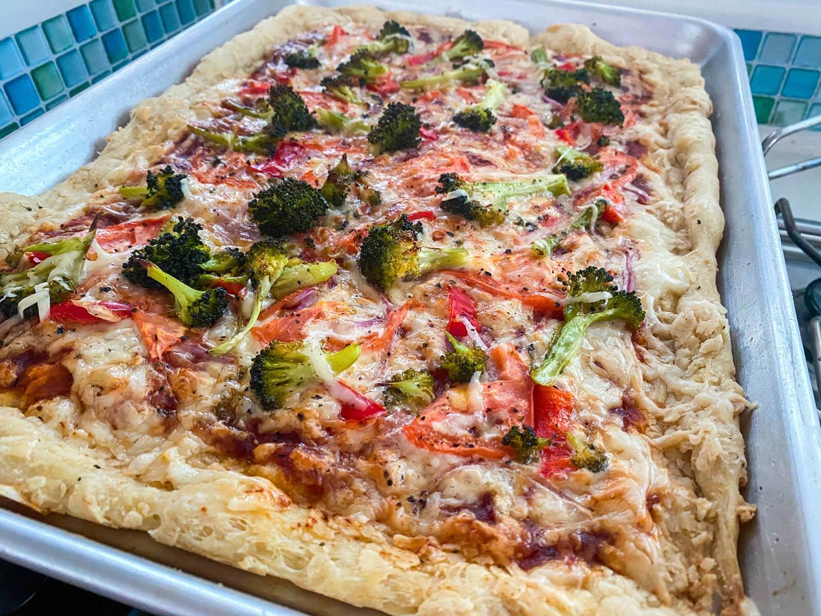 pizza with tomato, onion, and broccoli