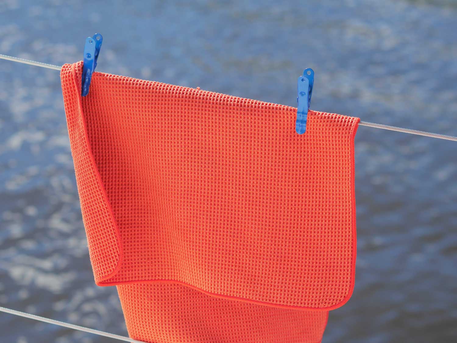 clothespin holding towel on lifeline of boat