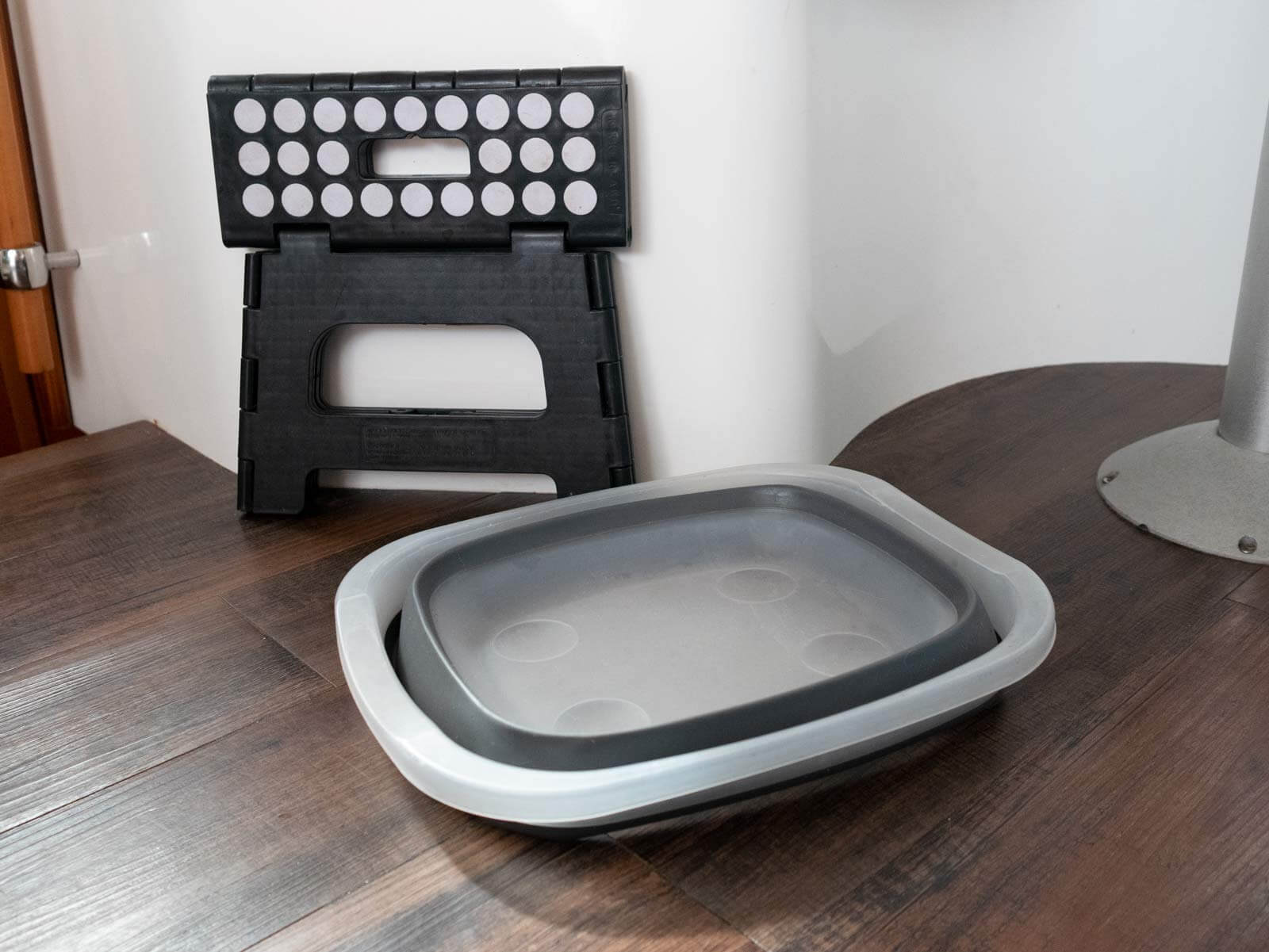 collapsible stool and bin on the floor of the galley