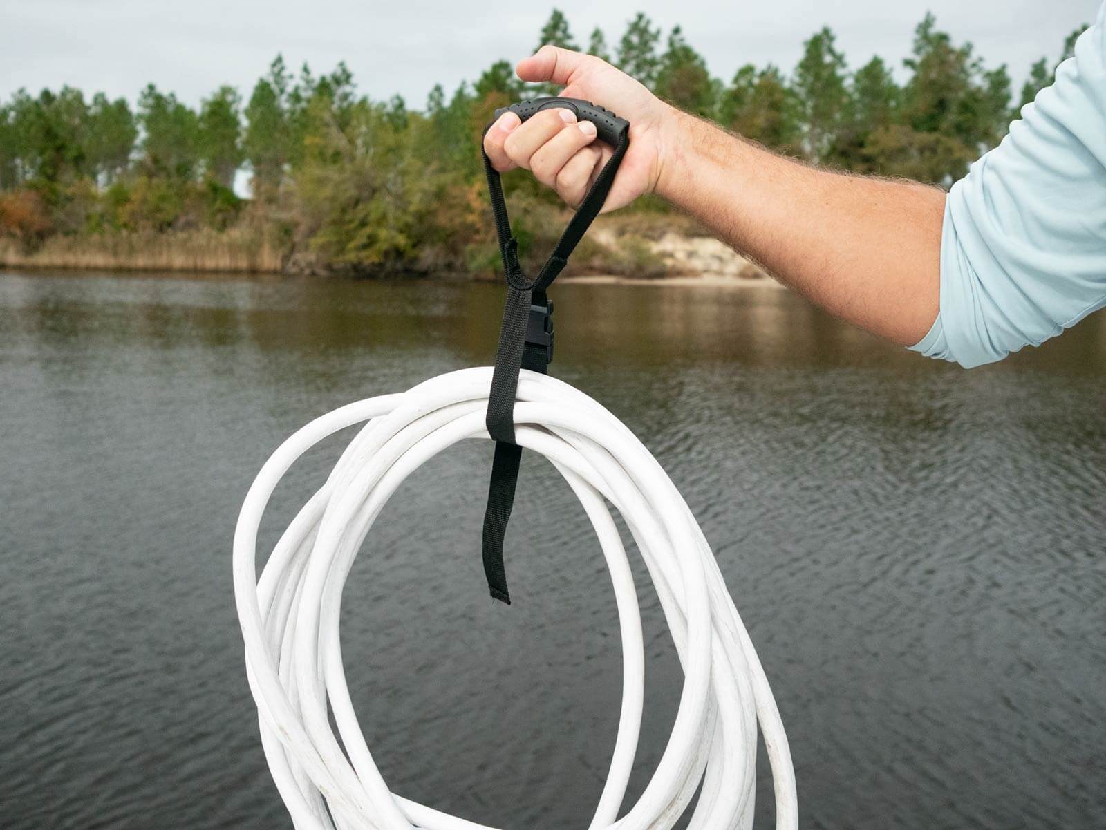 man holding up power cable with Camco strap