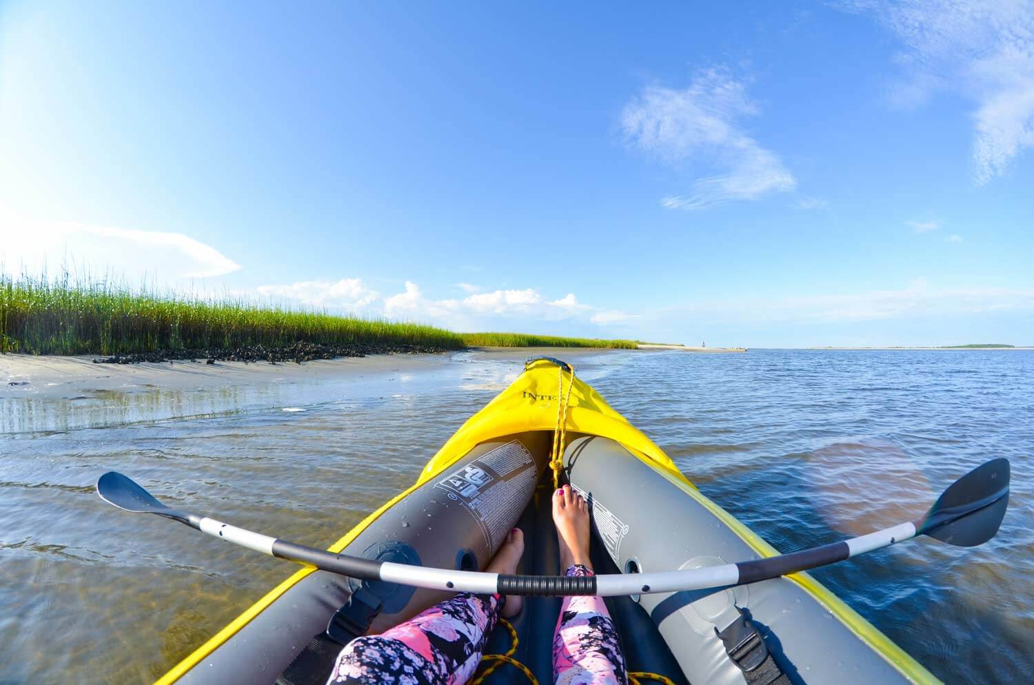 woman relaxing in kayak on water beside beach