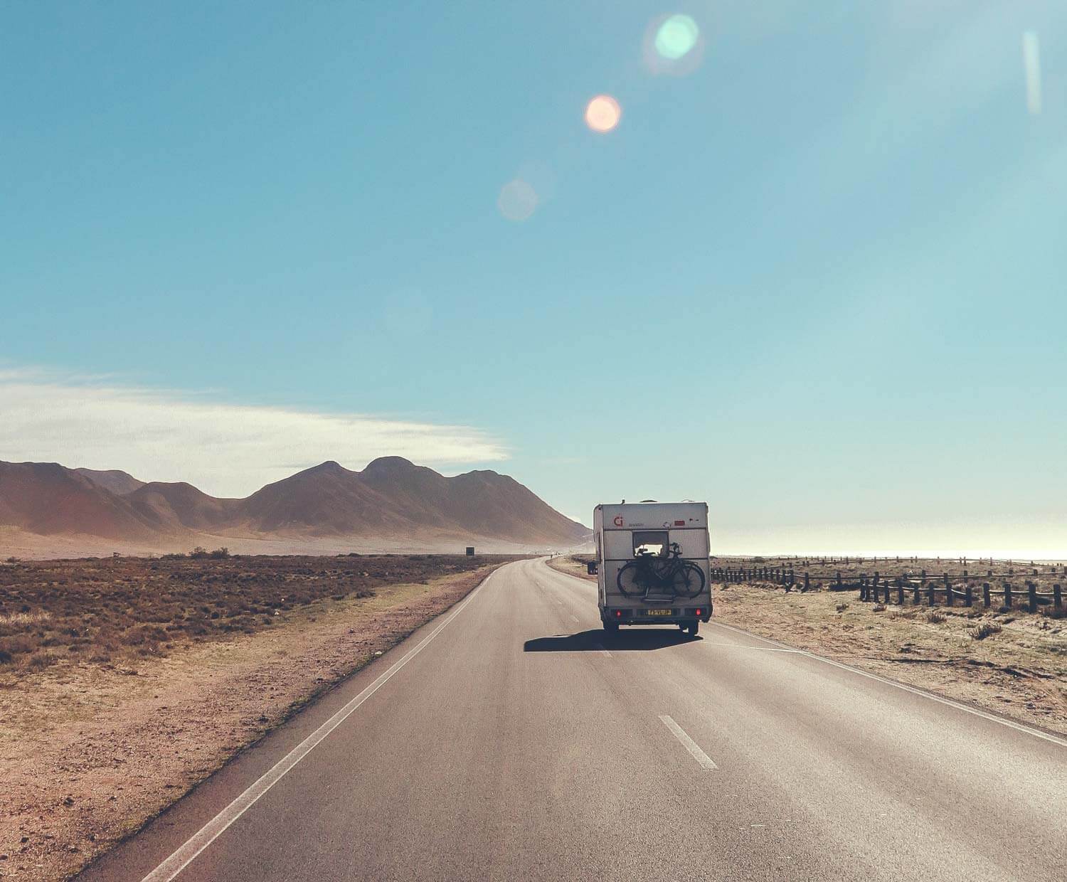 Motorhome driving down the road with bikes on the back