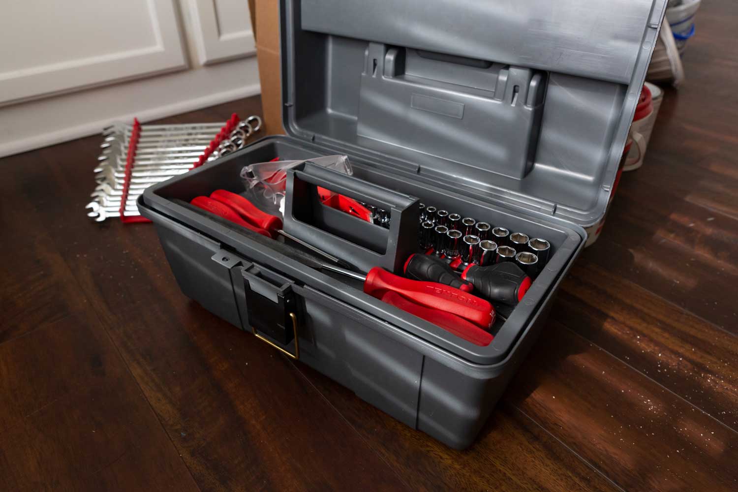 Tool kit with tools inside and wrenches on the floor