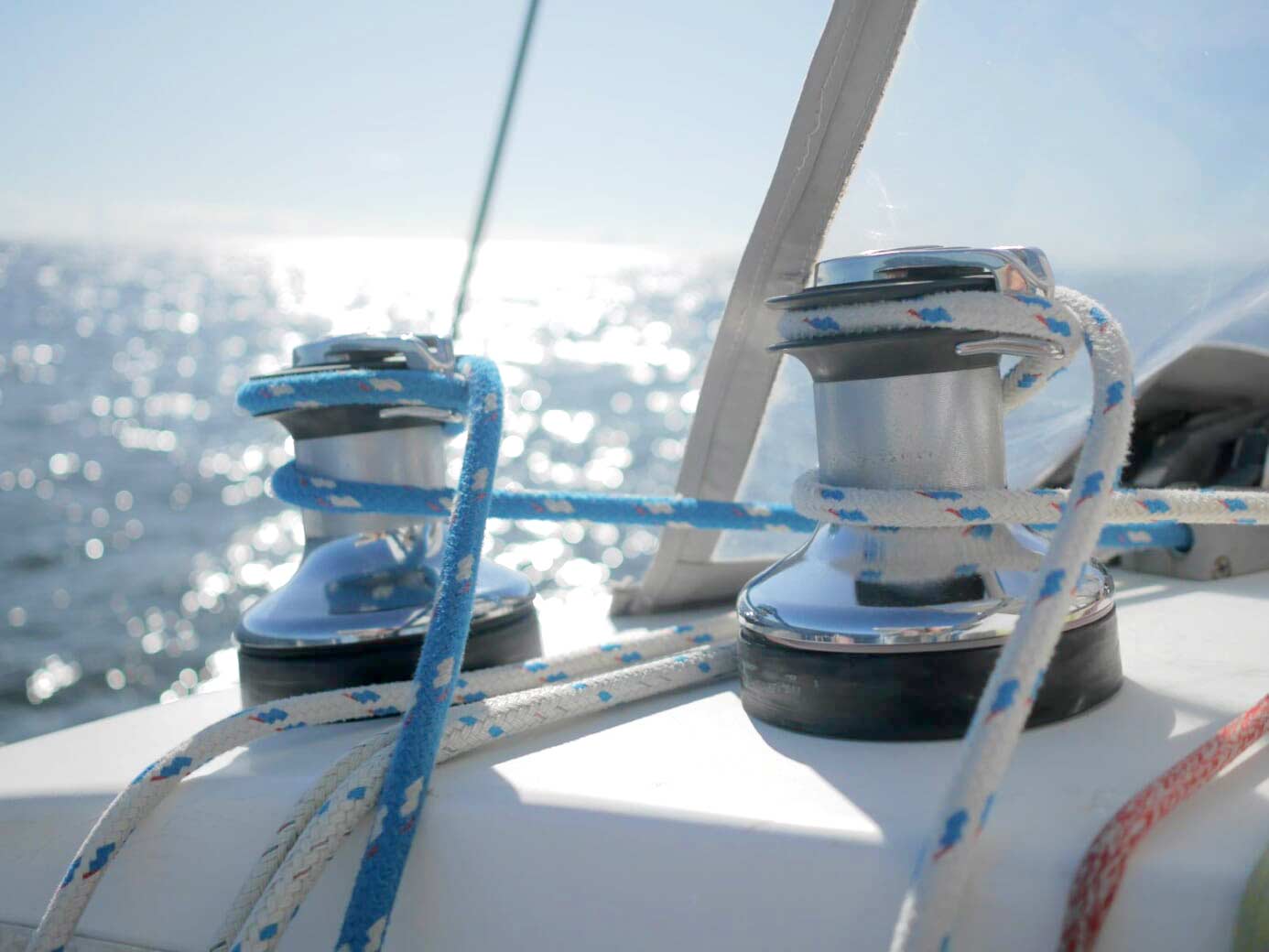 Lines on winches run to the helm of a sailboat