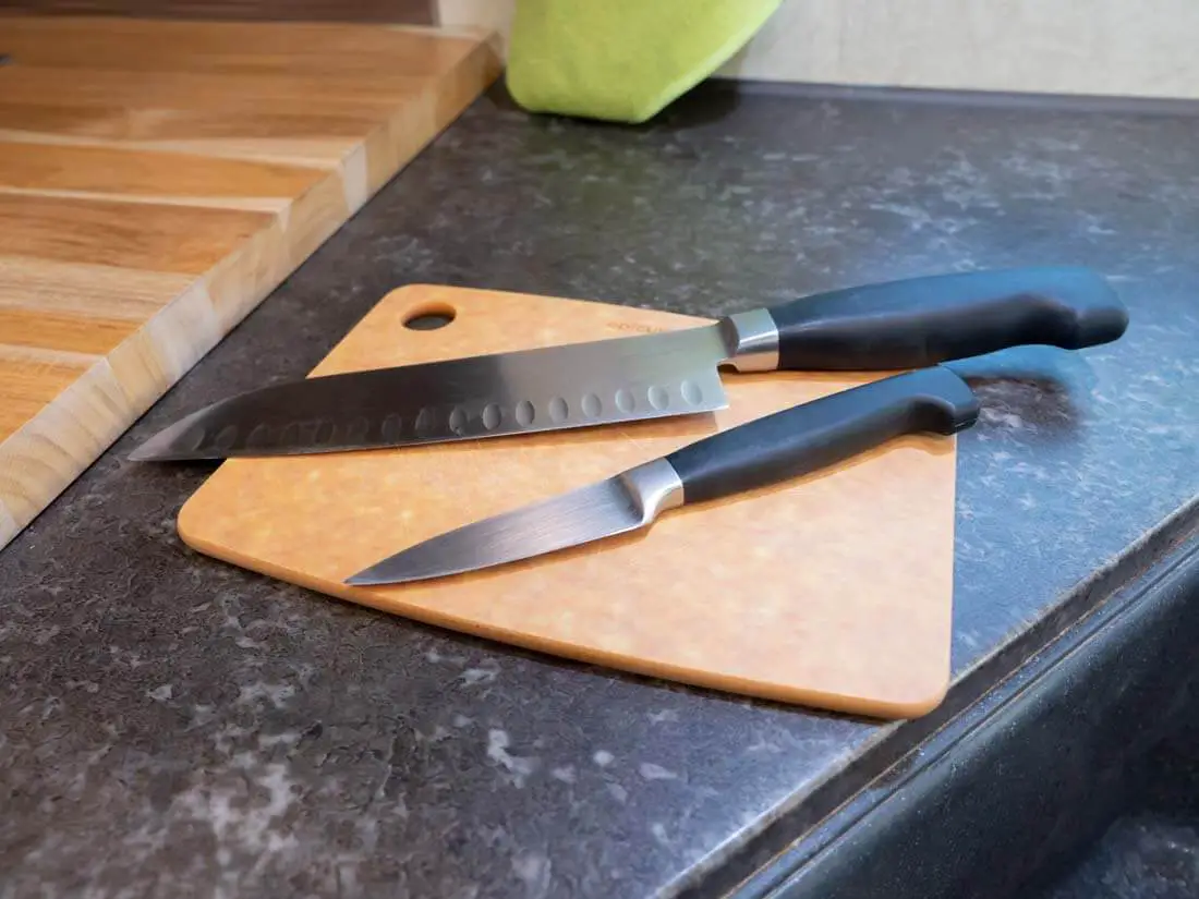 chef and pairing knife on a small cutting board