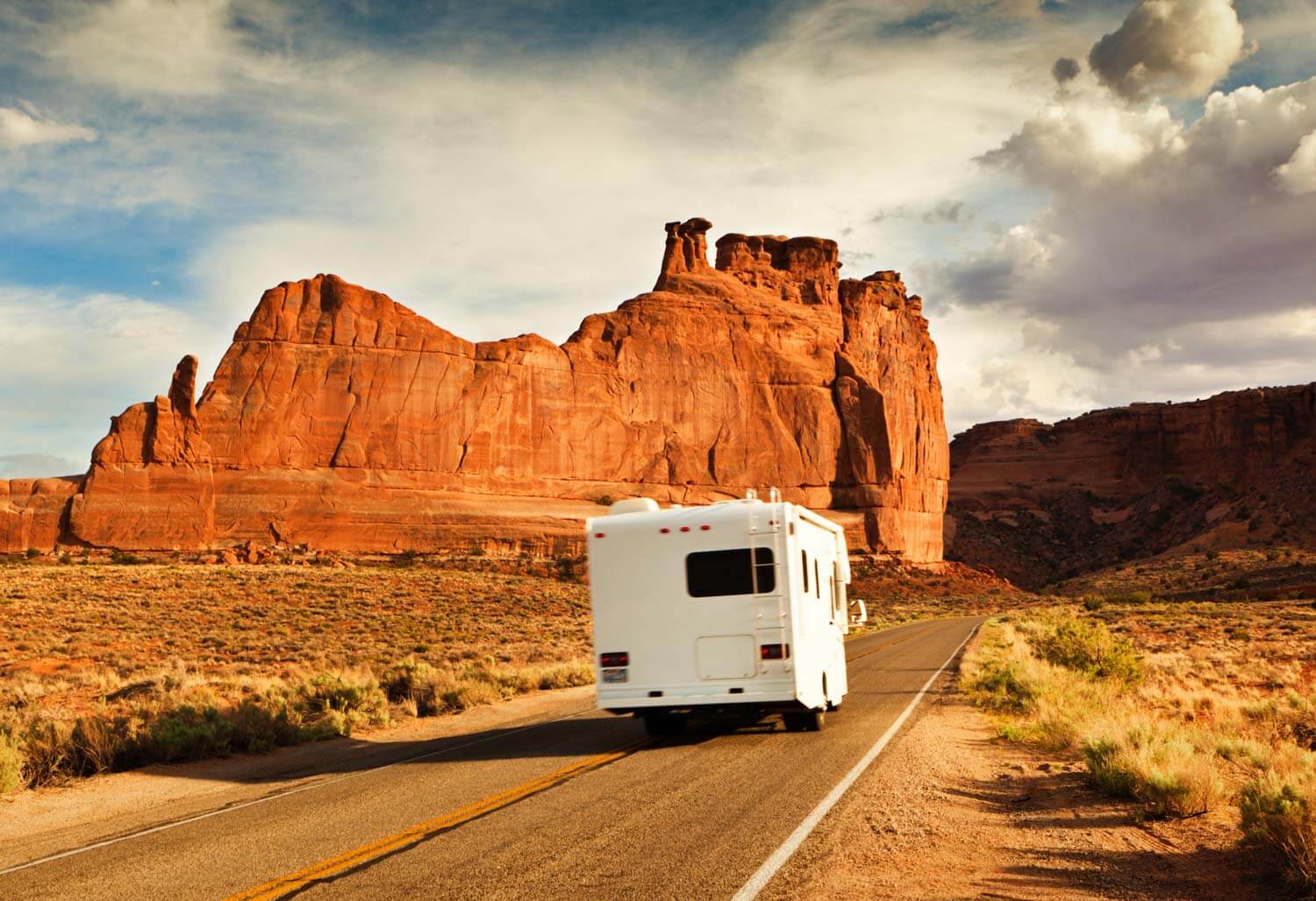 Motorhome on the road in a desert mountain landscape