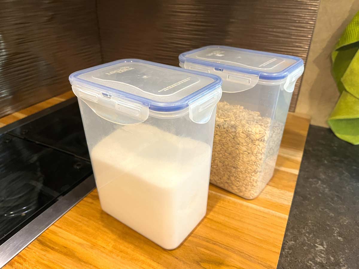 Vertical food storage containers holding sugar and cereal on the RV counter.