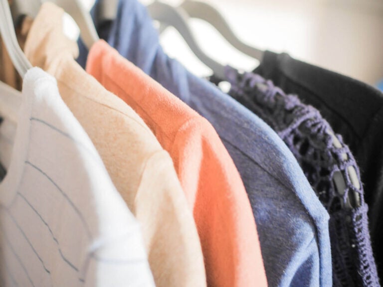 close up of clothes organized hanging in closet