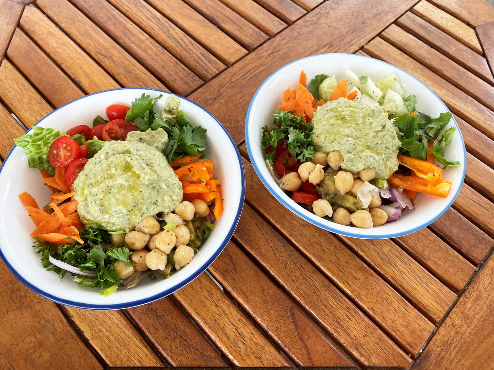 Buddha bowls with lettuce, carrots, peppers, chickpeas, tomatoes and hummus