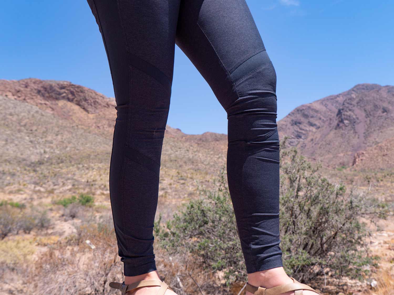 close up of woman's hiking pants with mountains in background