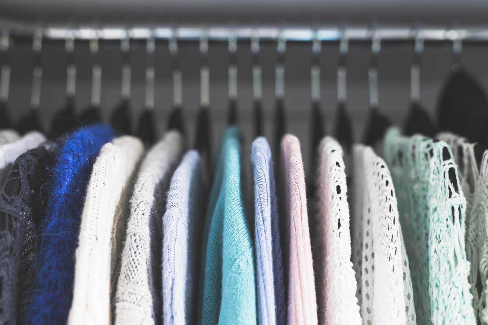 sweaters hanging in closet