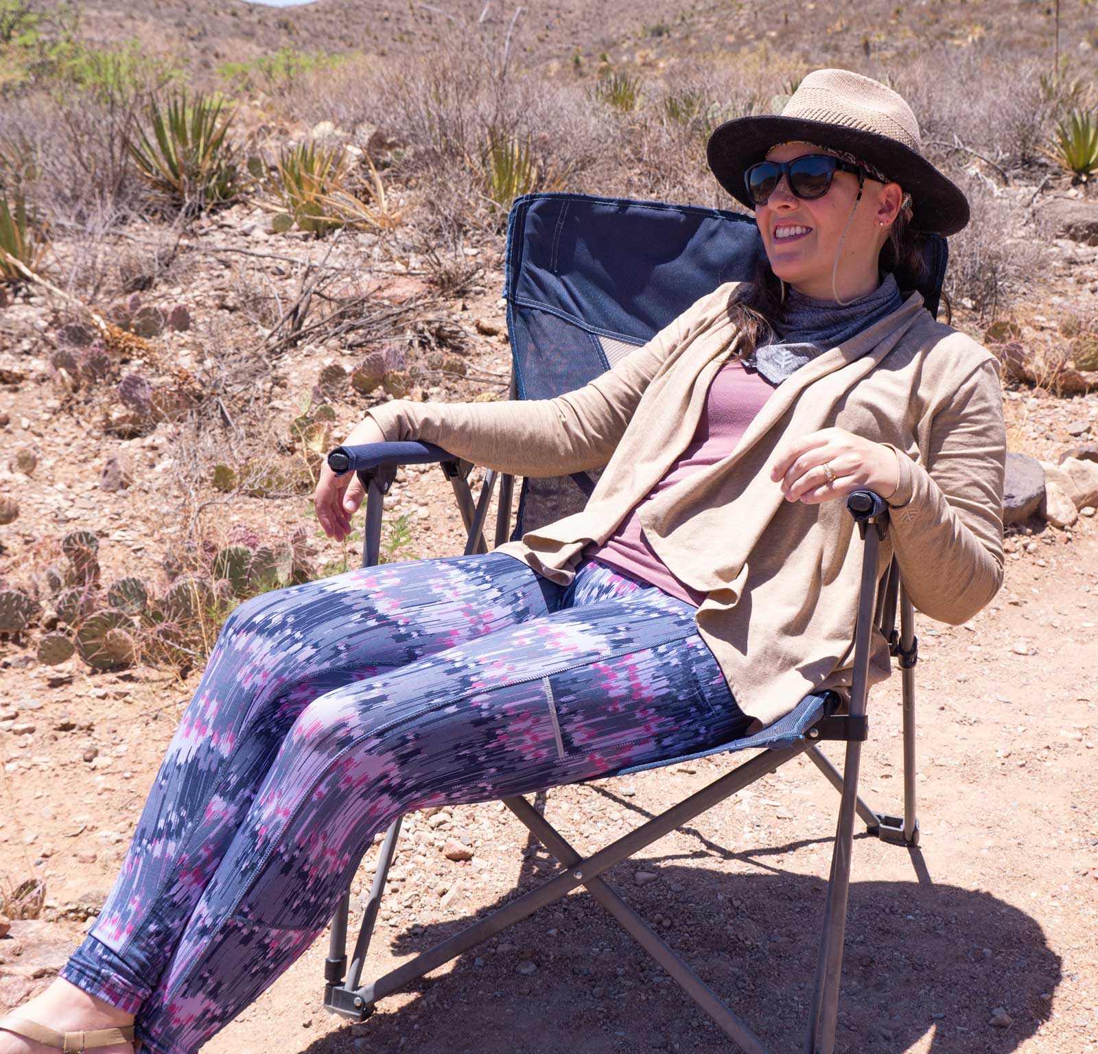 woman dressed in outdoor clothes sitting in camping chair