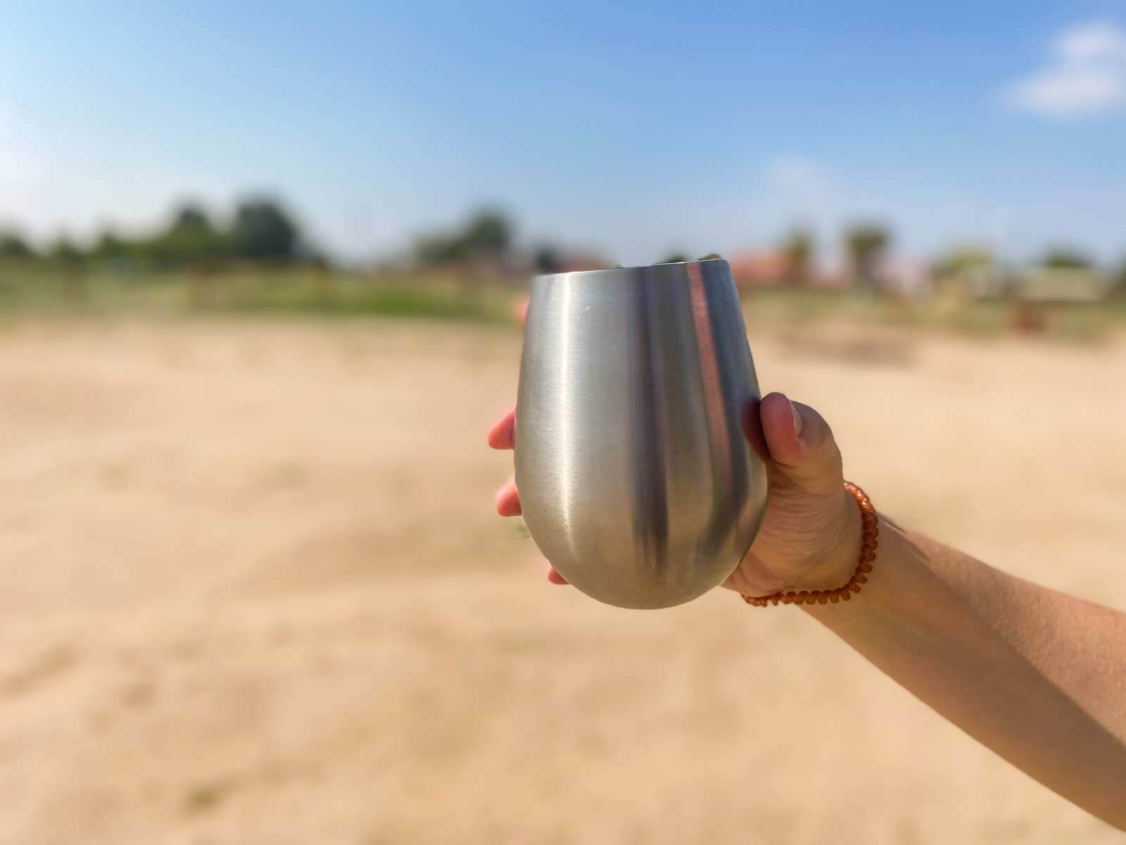 woman holding wine glass over desert camping area