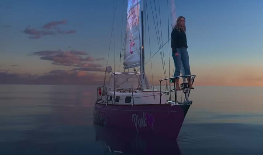Jessica Watson on the bow of her sailboat in the calm ocean