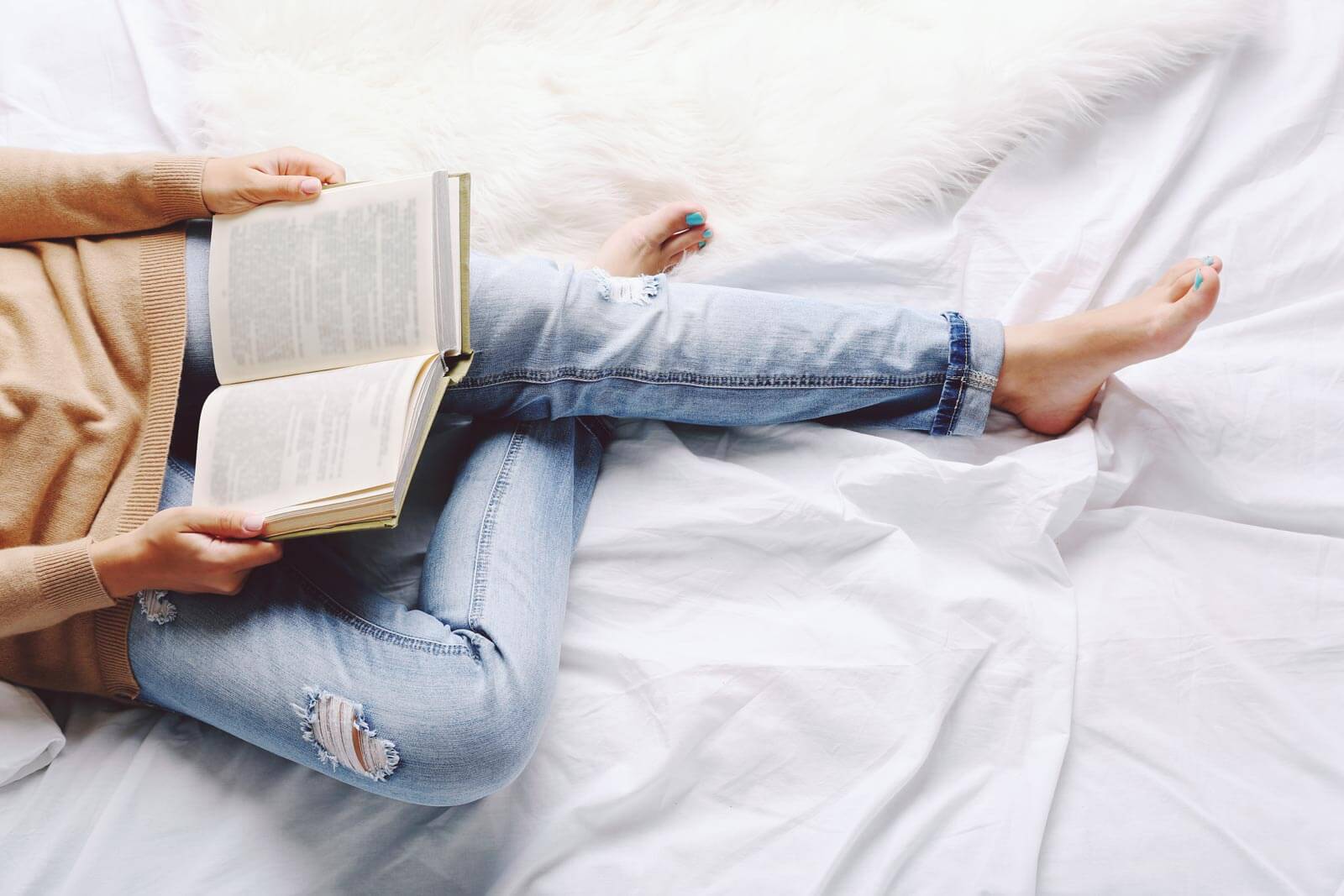 woman on bed reading book
