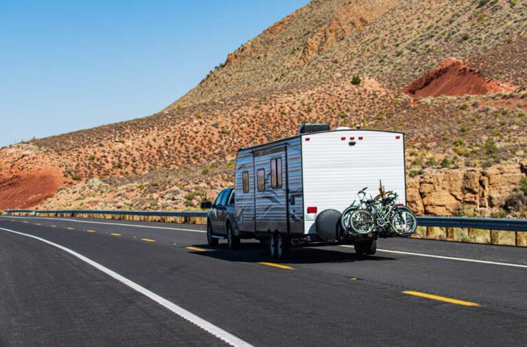 RV travel trailer on road in the desert