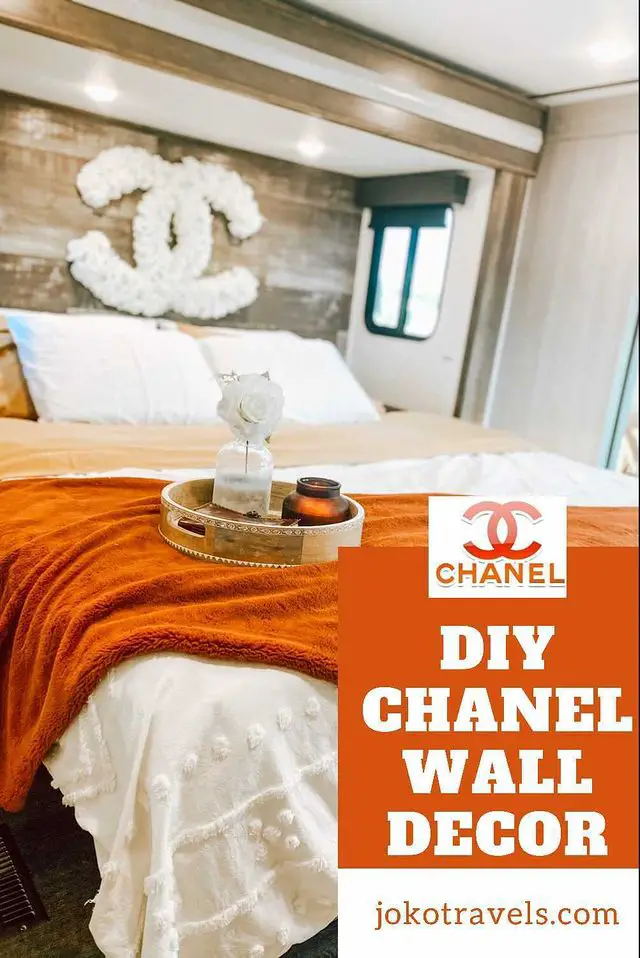 DIY Chanel wall decor - chanel logo made of white flowers hanging over bed