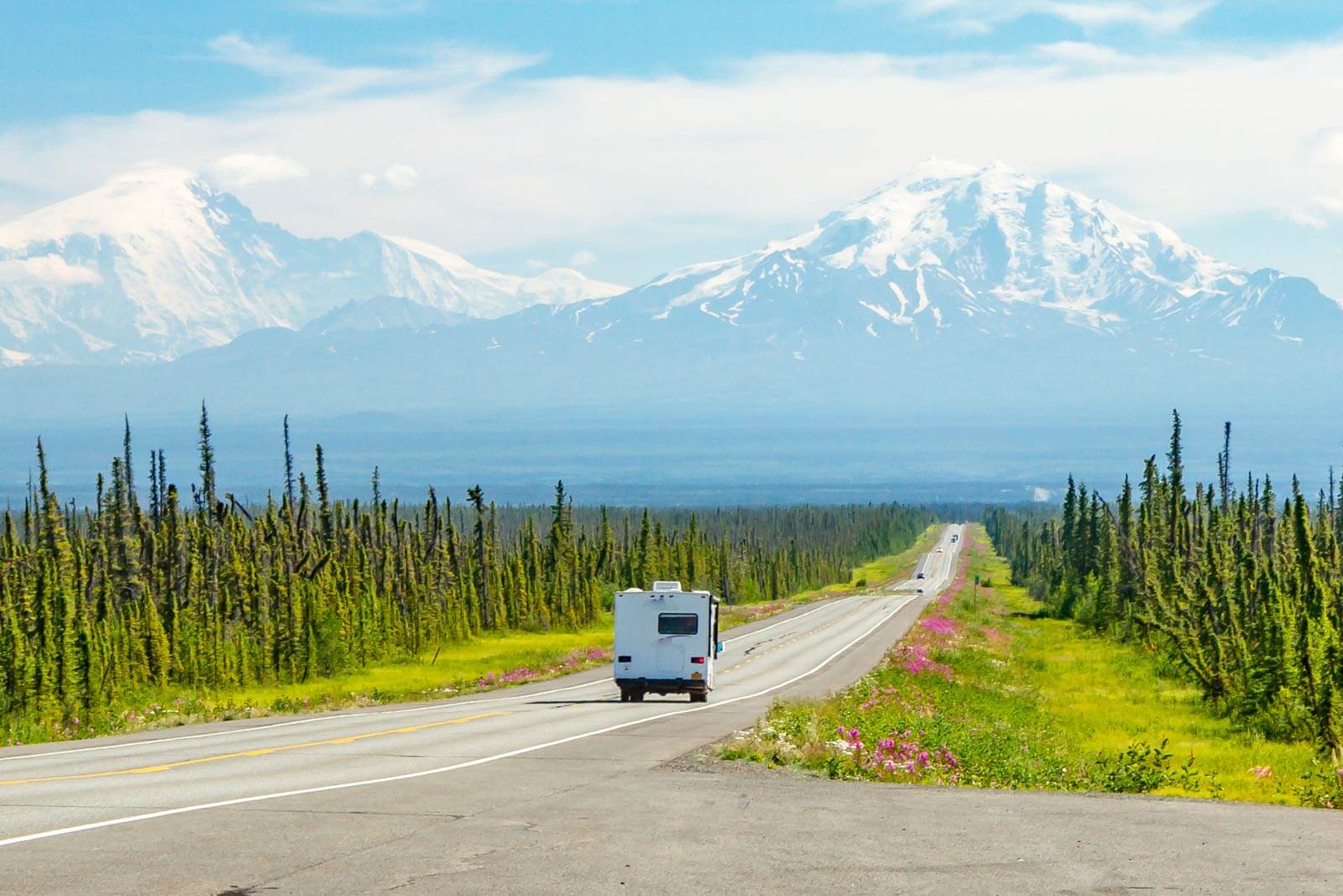 RV driving on open road toward mountains