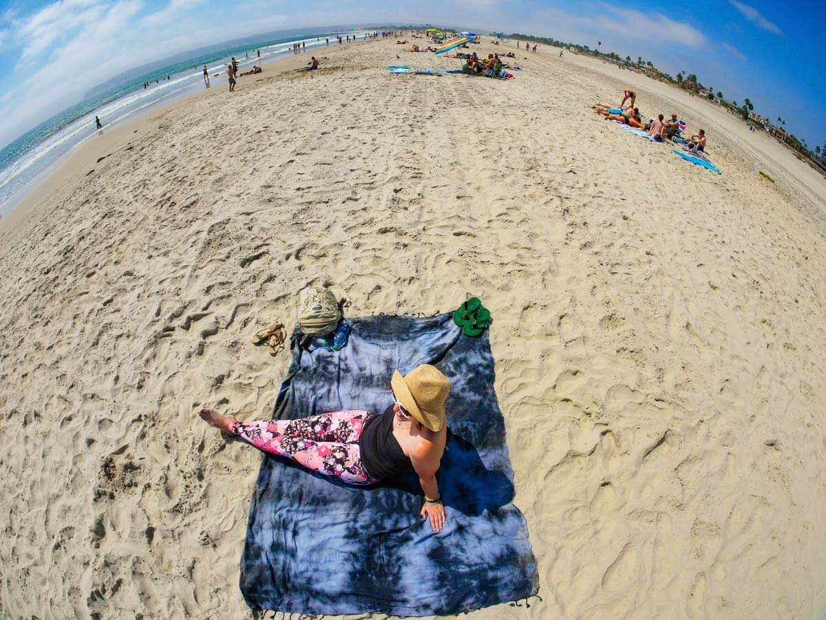 wide angle of woman laying on California beach