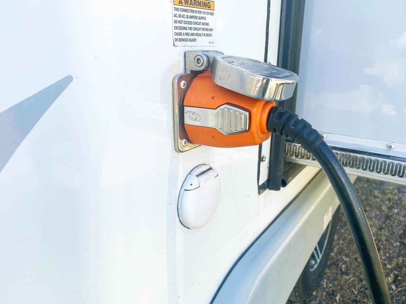 RV power cord plugged into RV shore power outlet.