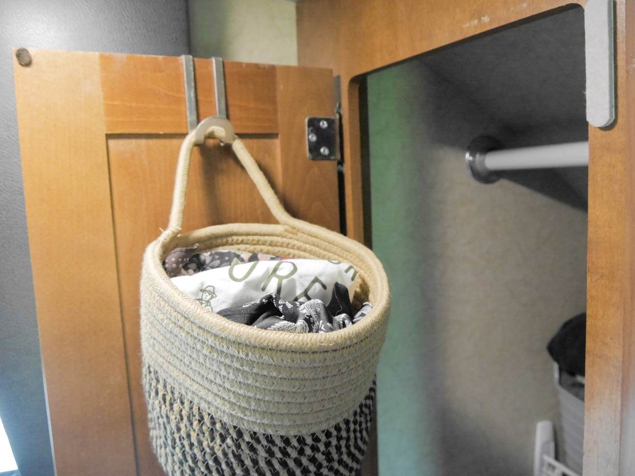 small basket with clothing items hanging from hook on rv closet door