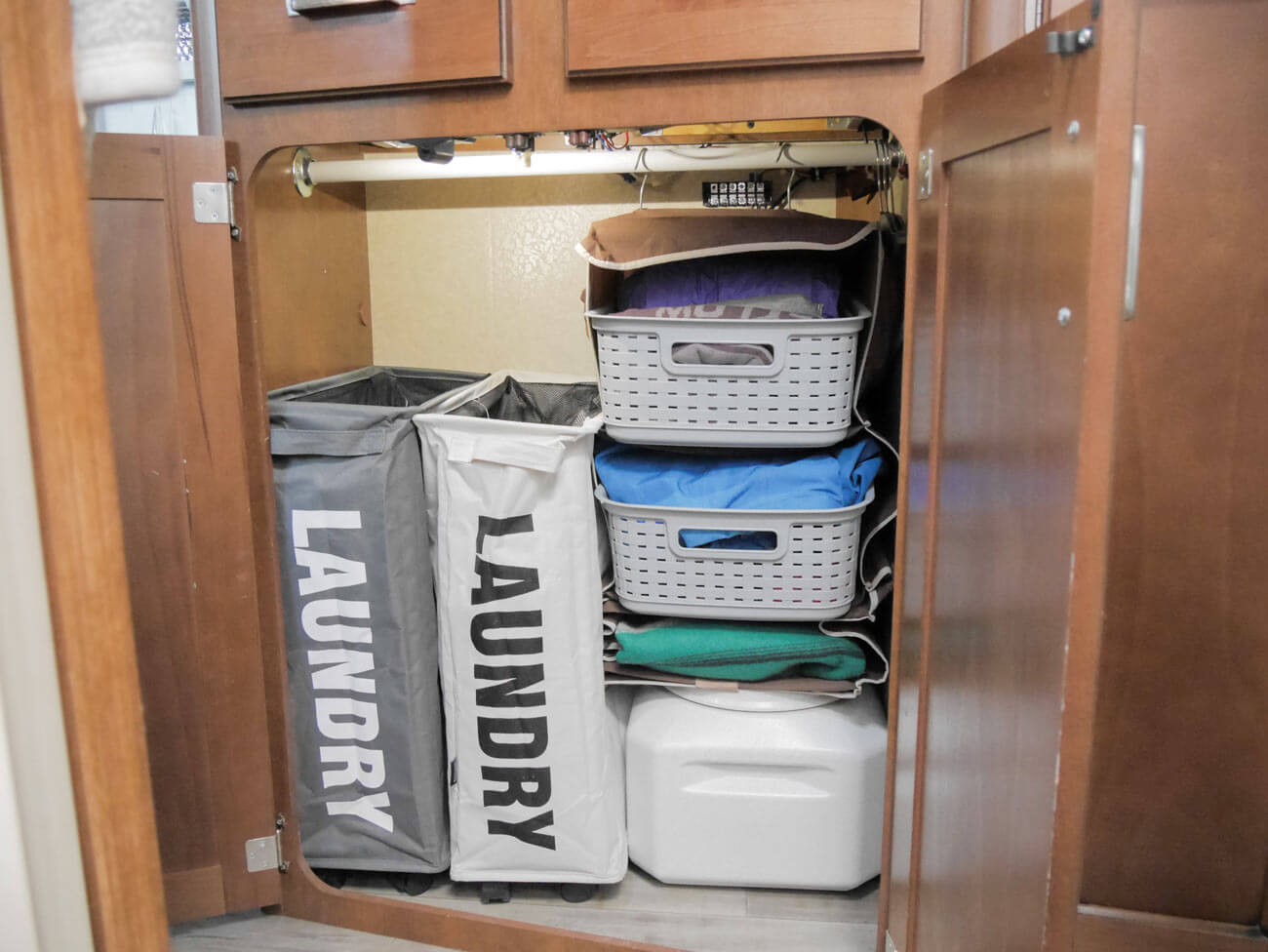 rv closet storage with laundry baskets and hanging organizer