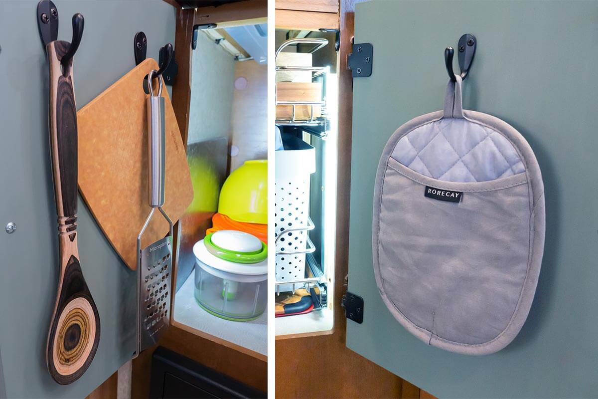 kitchen utensils, cutting board, and pot holder hanging from custom hooks on the inside of cabinet doors