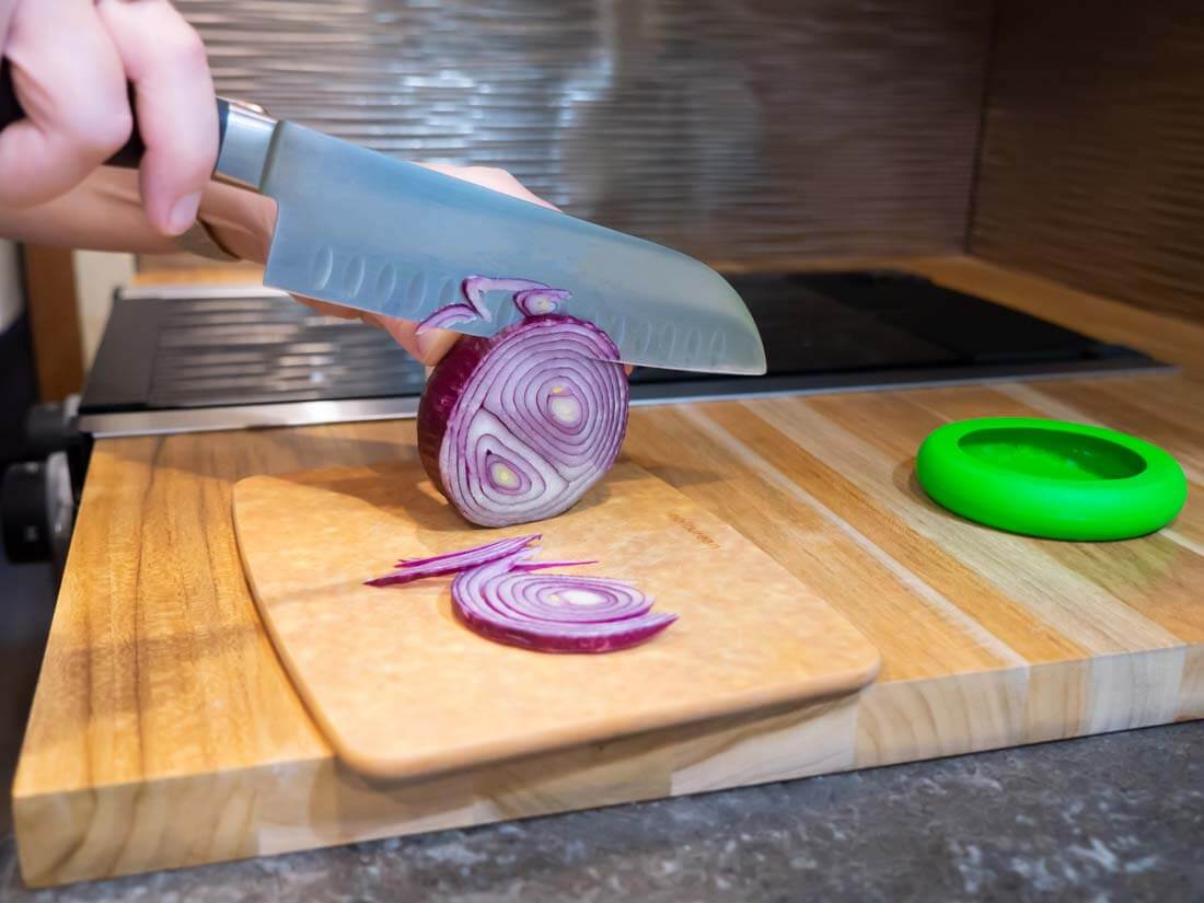 Knife cutting through a red onion on an RV kitchen countertop.