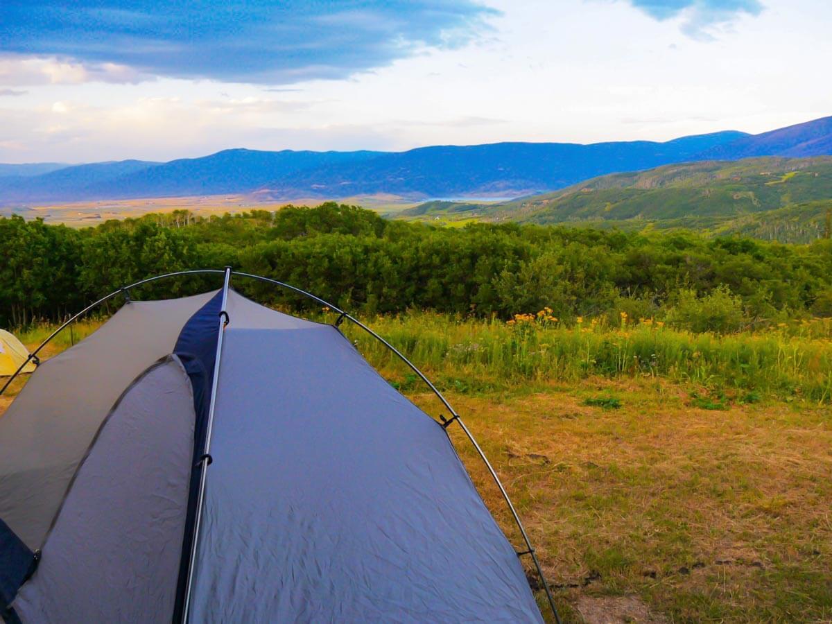 close up of tent with beautiful mountain scape in the background