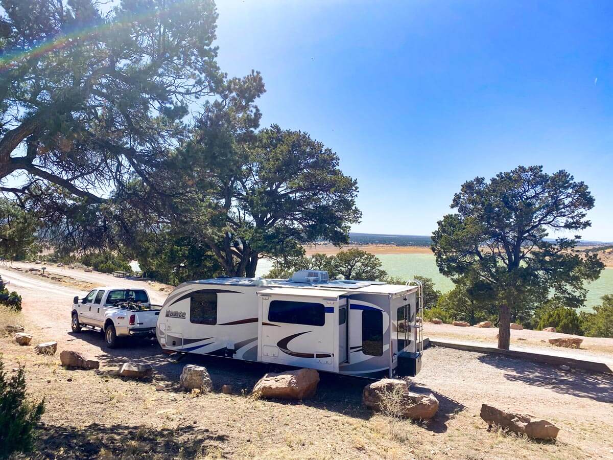 RV in dry campsite with lake in the background.
