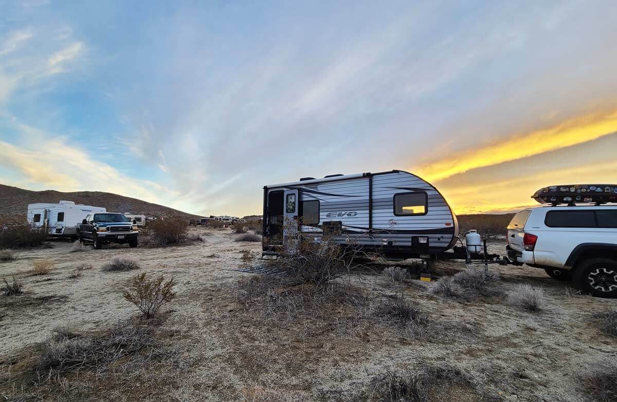 Travel trailer toy hauler parked in the desert.
