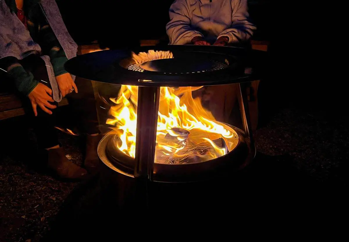 Solo Stove fire pit at night at a campsite with big flame.