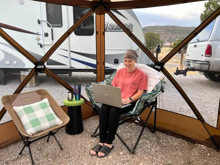RVer working at a computer in a popup CLAM gazebo.