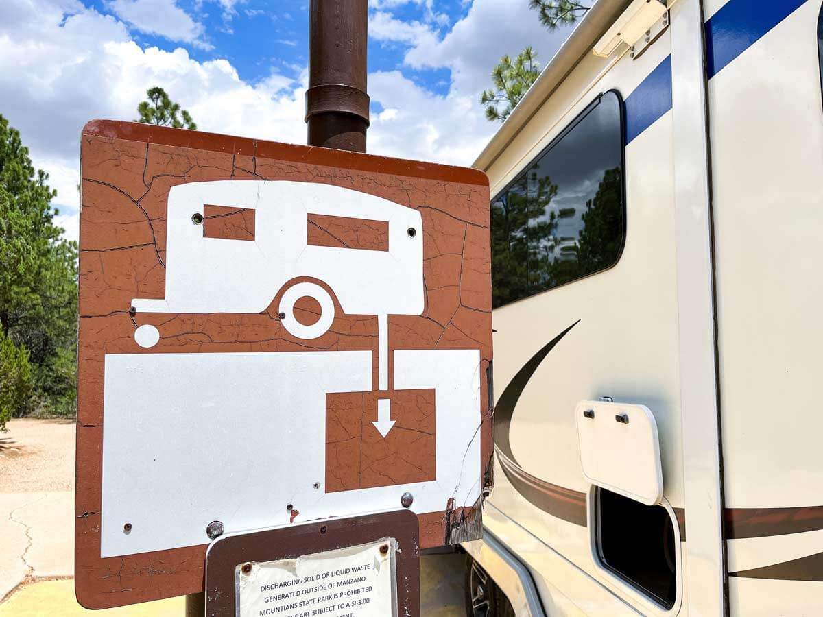 RV dump station sign beside a travel trailer.