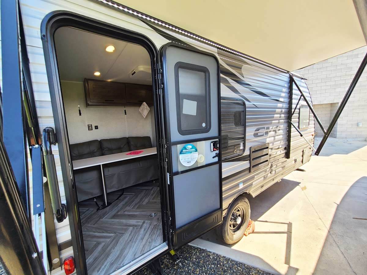 Door open to inside of toy hauler travel trailer living space.
