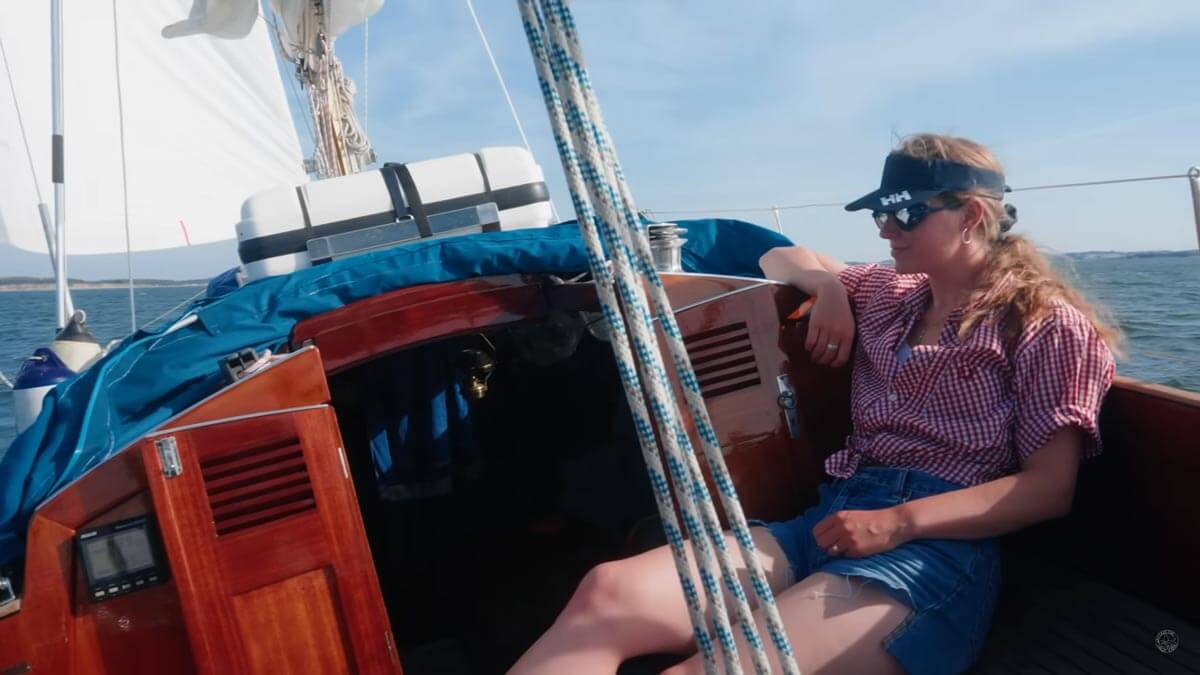 Screenshot of Sailing Magic Carpet YouTube video with Maya in the cockpit of vessel under sail.
