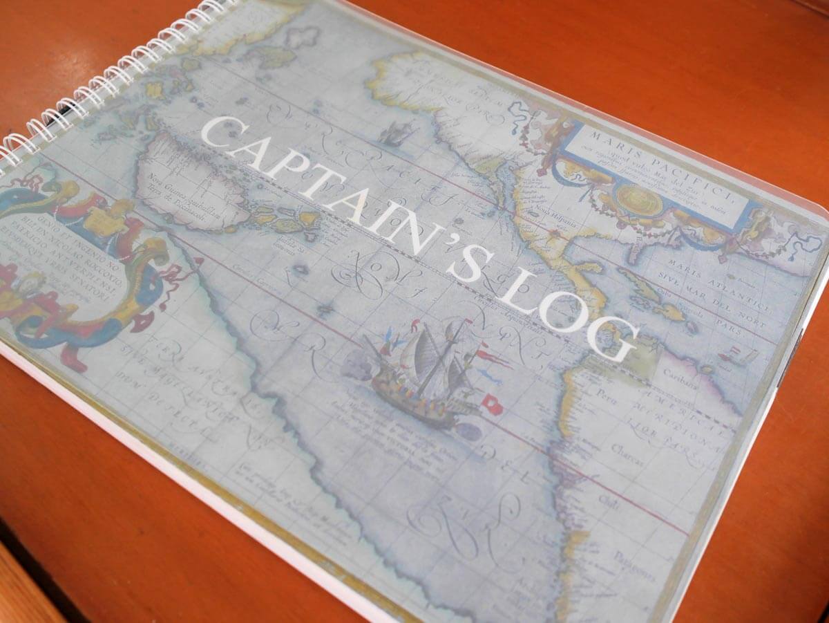 Captain's log book on navigation station in sailboat.