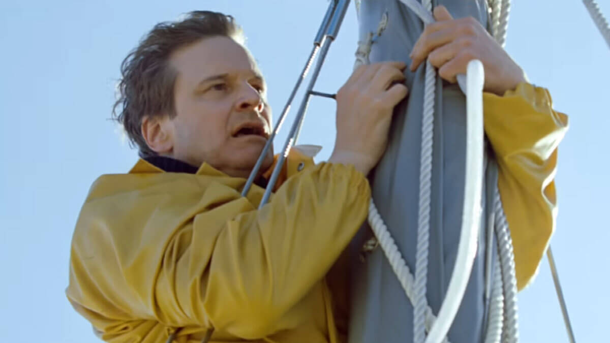 The Mercy video trailer thumbnail of Colin Firth on top of a sailboat mast in a rain coat.